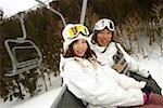 Young Asian man and woman on ski lift