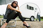 Woman Sitting on Lawn Chair by Trailer