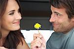 Woman Looking at Man Holding Flower