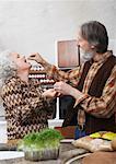 Man Feeding Woman in Kitchen