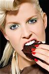 Woman biting a slice of cake