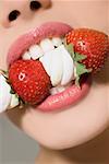 Woman biting strawberries and marshmallows