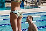 Side profile of a mid adult man in a swimming pool beside a woman
