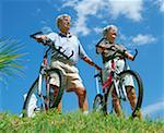 Vue angle faible sur un permanent de couple senior avec leur vélo, Bermudes