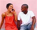 Close-up of a young woman sitting with a young man and talking on a mobile phone, Bermuda