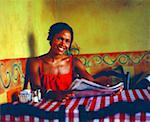 Portrait of a young woman holding a newspaper and smiling in a restaurant, Bermuda