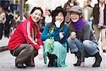 Portrait de trois jeunes femmes debout sur la rue