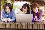 Trois jeunes femmes se trouvant en face d'un ordinateur portable