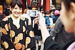 Femme prenant une photographie d'une jeune femme