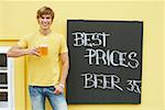 Portrait of a young man holding a glass of beer