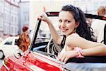 Portrait of a young woman sitting in a car and smiling