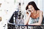 Close-up of a young woman talking on a mobile phone in the balcony