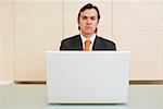 Porträt eines Unternehmers vor einem laptop