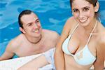 Mid adult man and a young woman smiling in a swimming pool