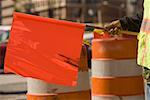 Mid section view of a man holding a red flag at a construction site