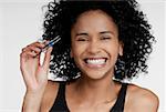 Portrait of a young woman holding a pair of eyebrow tweezers