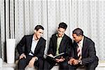 Three businessmen reading a file