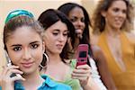 Portrait of a teenage girl talking on a mobile phone with three teenage girls behind her