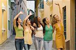 Five teenage girls standing together and waving