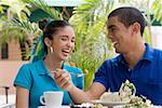 Close-up of a young man and a teenage girl sitting in a restaurant and smiling