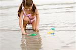 Girl playing with toys on the beach