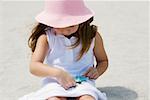 Close-up of a girl playing with a starfish on the beach