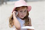 Close-up of a girl listening to a conch shell