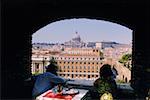 Touristes autour d'une table à manger en regardant une basilique, la Basilique de St. Pierre, Rome, Italie