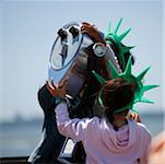 Three people standing near coin- operated binoculars, New York City, New York State, USA