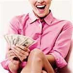 Close-up of a businesswoman holding dollar bills and laughing
