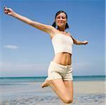 Close-up of a young woman jumping on the beach