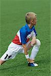 Joueur de football qui s'étend dans un terrain de soccer