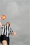 Low angle view of a soccer player tossing a soccer ball