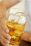 Close-up of a human hand holding a glass of whiskey