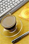 Close-up of a cup of black coffee and a pen