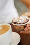 Close-up of a person's hand holding a cupcake