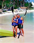 Senior couple tenant des avirons et regardant de l'autre sur la plage, Bermudes