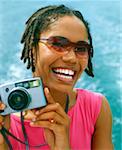 Portrait of a young woman holding a digital camera and smiling, Bermuda