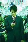 Mid adult man operating a mobile phone in a train