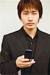 Portrait of a young man holding a mobile phone