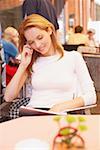 Jeune femme parlant sur un téléphone mobile dans un restaurant