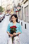 Portrait of a young woman holding a bouquet of flowers