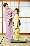 Mature woman adjusting her daughter's Kimono