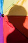 Close-up of a person's shadow on a colorful umbrella