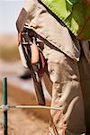 Mid section view of a construction worker carrying hand tools