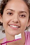 Portrait d'une jeune femme avec une brosse à dents devant sa bouche