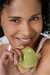 Portrait of a young woman holding an apple and smiling