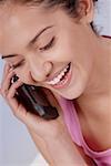 Portrait d'une jeune femme parlant sur un téléphone mobile et souriant