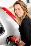 Portrait of a young woman refueling a car