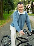 Portrait of a mid adult man cycling in a park